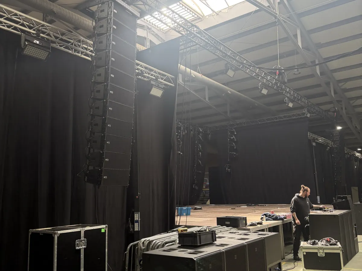 Opgebouwd podium met geluidssysteem en technicus